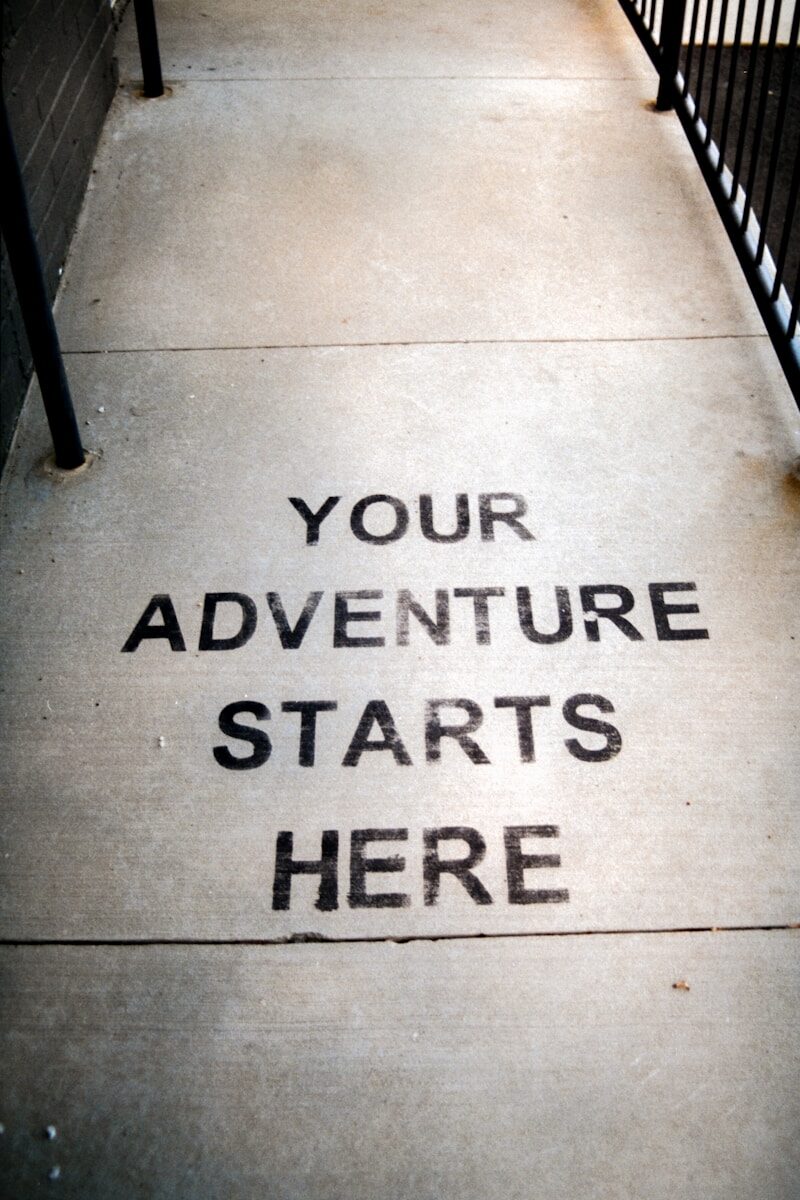 Your adventure starts here painted on sidewalk.
